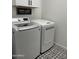 Modern laundry room with a front-load washer and dryer set and stylish patterned tile flooring at 19864 W San Juan Ave, Litchfield Park, AZ 85340
