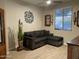 Comfortable living room featuring a gray sectional sofa, wood-look tile flooring, and stylish wall decor at 19864 W San Juan Ave, Litchfield Park, AZ 85340