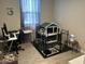 Functional office space with a desk, chair, computer setup, and an enclosed pet habitat at 19864 W San Juan Ave, Litchfield Park, AZ 85340