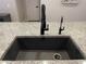 Close up of the kitchen island sink featuring a black faucet and granite countertop at 19864 W San Juan Ave, Litchfield Park, AZ 85340