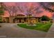 Stunning home with a circular driveway, fountain and mature landscaping, shown at sunset at 2005 N Pomelo --, Mesa, AZ 85215