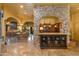 Open concept kitchen and bar area with stone archway, custom cabinetry, and tile floors at 2005 N Pomelo --, Mesa, AZ 85215