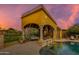 Covered outdoor patio with seating overlooking a luxurious pool and rock waterfall feature at 2005 N Pomelo --, Mesa, AZ 85215