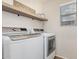 Bright laundry room with modern appliances and a rustic shelf at 2116 S Moccasin Trl, Gilbert, AZ 85295