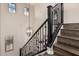 View of staircase with wood steps and black iron railing and sphere chandelier and bright natural light at 2116 S Moccasin Trl, Gilbert, AZ 85295