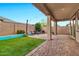 A covered patio, artificial grass, and a seating area make a charming backyard at 22800 E Via Las Brisas Rd, Queen Creek, AZ 85142