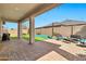 A beautiful backyard features a covered patio with pavers and artificial grass at 22800 E Via Las Brisas Rd, Queen Creek, AZ 85142