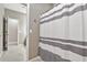 Neutral-colored bathroom featuring a shower with a striped curtain, tiled floors, and great lighting at 22800 E Via Las Brisas Rd, Queen Creek, AZ 85142