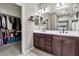 Bathroom view featuring dual sinks and a walk-in closet with custom shelving at 22800 E Via Las Brisas Rd, Queen Creek, AZ 85142