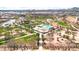 Aerial view featuring a resort-style community pool, green spaces, and palm trees for relaxation and recreation at 22800 E Via Las Brisas Rd, Queen Creek, AZ 85142