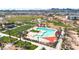 This aerial shot showcases a pool area with palm trees, a shade structure, playground, and green space for community recreation at 22800 E Via Las Brisas Rd, Queen Creek, AZ 85142