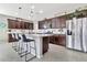 Kitchen featuring an island with seating, granite counters, stainless appliances, and tiled backsplash at 22800 E Via Las Brisas Rd, Queen Creek, AZ 85142