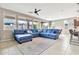 Open concept living room featuring a sectional sofa, large windows, and tile flooring at 22800 E Via Las Brisas Rd, Queen Creek, AZ 85142