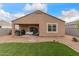 Backyard featuring synthetic grass, desert landscaping, and covered patio with outdoor furniture at 2426 E San Gabriel Trl, Casa Grande, AZ 85194