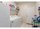 Functional laundry room featuring a white washer and dryer, storage shelves and a door at 2426 E San Gabriel Trl, Casa Grande, AZ 85194