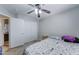 Bright bedroom with ceiling fan, tan flooring and view into ensuite bathroom at 2501 N 114Th Ave, Avondale, AZ 85392