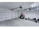 Spacious garage with weightlifting area, overhead storage and white garage door at 2501 N 114Th Ave, Avondale, AZ 85392