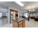 View of the kitchen extending into the adjacent living space, with granite countertops and stainless-steel appliances at 2501 N 114Th Ave, Avondale, AZ 85392