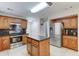 Well-lit kitchen features stainless steel appliances, granite counters, an island, and ample cabinet space for storage at 2501 N 114Th Ave, Avondale, AZ 85392