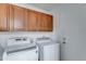 Laundry room with modern washer and dryer and upper cabinet storage at 2501 N 114Th Ave, Avondale, AZ 85392