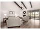 Inviting living room with high ceilings, wood beams, a cozy fireplace, and sliding glass doors to patio at 2537 N Miller Rd, Scottsdale, AZ 85257