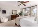 Bright main bedroom featuring slider glass doors to the outside, walk-in closet, and ceiling fan at 2537 N Miller Rd, Scottsdale, AZ 85257