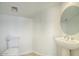 Bright powder room featuring a pedestal sink, oval mirror, and a modern toilet at 2868 E Clifton Ct, Gilbert, AZ 85295