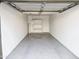 A clean one car garage with epoxy floors, a white door, and built-in shelving at 30 E Brown Rd # 2052, Mesa, AZ 85201