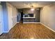 Bright living room with wood floors, ceiling fan, and track lighting leading to open concept kitchen at 30 E Brown Rd # 2052, Mesa, AZ 85201