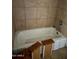 Bathroom featuring a shower-tub combo with tile surround and wood accents at 3211 W Bethany Home Rd, Phoenix, AZ 85017