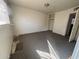 A simple carpeted bedroom featuring a window and a built-in closet at 3211 W Bethany Home Rd, Phoenix, AZ 85017