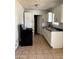 An interior view of a basic kitchen with white cabinets, a sink, and a black oven at 3211 W Bethany Home Rd, Phoenix, AZ 85017