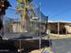 A trampoline in the backyard beneath a mature tree, creating a fun recreational space at 3211 W Bethany Home Rd, Phoenix, AZ 85017