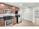 A kitchen area featuring stainless steel appliances, dark counter tops, and wood cabinets at 3507 E Erie St, Gilbert, AZ 85295