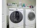 Clean and organized laundry room with white Samsung washer and dryer sets, and shelf storage at 3542 E Pala Ct, Gilbert, AZ 85297