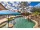 Sparkling pool with rock waterfall, umbrella, and lush landscaping at 3542 E Pala Ct, Gilbert, AZ 85297