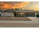 Charming single-story home with a two-car garage and xeriscaped front yard at sunset at 3619 E Friess Dr, Phoenix, AZ 85032