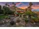 Scenic backyard view featuring lush landscaping, a stone pathway, and palm trees against a mountain backdrop at 5254 E Arroyo Rd, Paradise Valley, AZ 85253