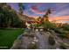 Picturesque backyard featuring lush landscaping, a stone pathway, and palm trees against a mountain backdrop at 5254 E Arroyo Rd, Paradise Valley, AZ 85253