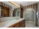 Vintage-style bathroom with a tiled counter, wood cabinets, and walk-in shower at 5254 E Arroyo Rd, Paradise Valley, AZ 85253