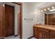 Bathroom vanity with tiled countertop, wood cabinets, and mirror with lighting at 5254 E Arroyo Rd, Paradise Valley, AZ 85253