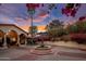 Charming home featuring bougainvillea accents, a circular driveway, a fountain and elegant arched architecture at 5254 E Arroyo Rd, Paradise Valley, AZ 85253