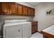 Functional laundry room featuring oak cabinets, tile countertops, and modern appliances at 5254 E Arroyo Rd, Paradise Valley, AZ 85253