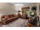 Cozy living room with a comfortable leather sofa, patterned rug, and a view to the exterior at 5254 E Arroyo Rd, Paradise Valley, AZ 85253