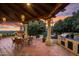 Outdoor patio featuring a built-in BBQ, dining area, lush landscaping, and a scenic sunset view at 5254 E Arroyo Rd, Paradise Valley, AZ 85253