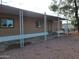 Exterior of home showing carport, gravel landscaping, and a covered front porch with a door at 549 E Mckellips Rd # 55, Mesa, AZ 85203