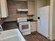 Close-up view of the kitchen featuring new appliances, dark countertops, tile backsplash, and a large sink at 549 E Mckellips Rd # 55, Mesa, AZ 85203