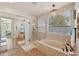 Luxurious bathroom featuring a soaking tub, glass shower, chandelier, and stylish finishes at 5779 S Penrose Dr, Gilbert, AZ 85298