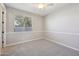 Neutral bedroom with a ceiling fan, carpeted floor, and bright window at 5779 S Penrose Dr, Gilbert, AZ 85298