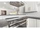 Modern kitchen with stainless steel range and oven, white cabinets, and a view into the living room at 749 E Montebello Ave # 228, Phoenix, AZ 85014